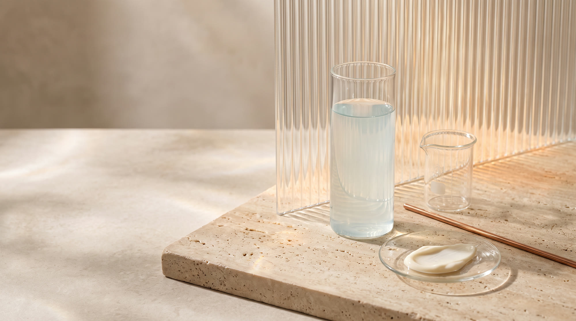 Peptide serum in fluted glassware on travertine, studio daylight